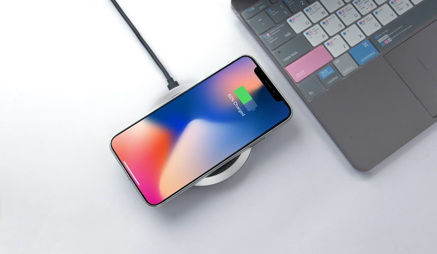 Phone charging next to a laptop