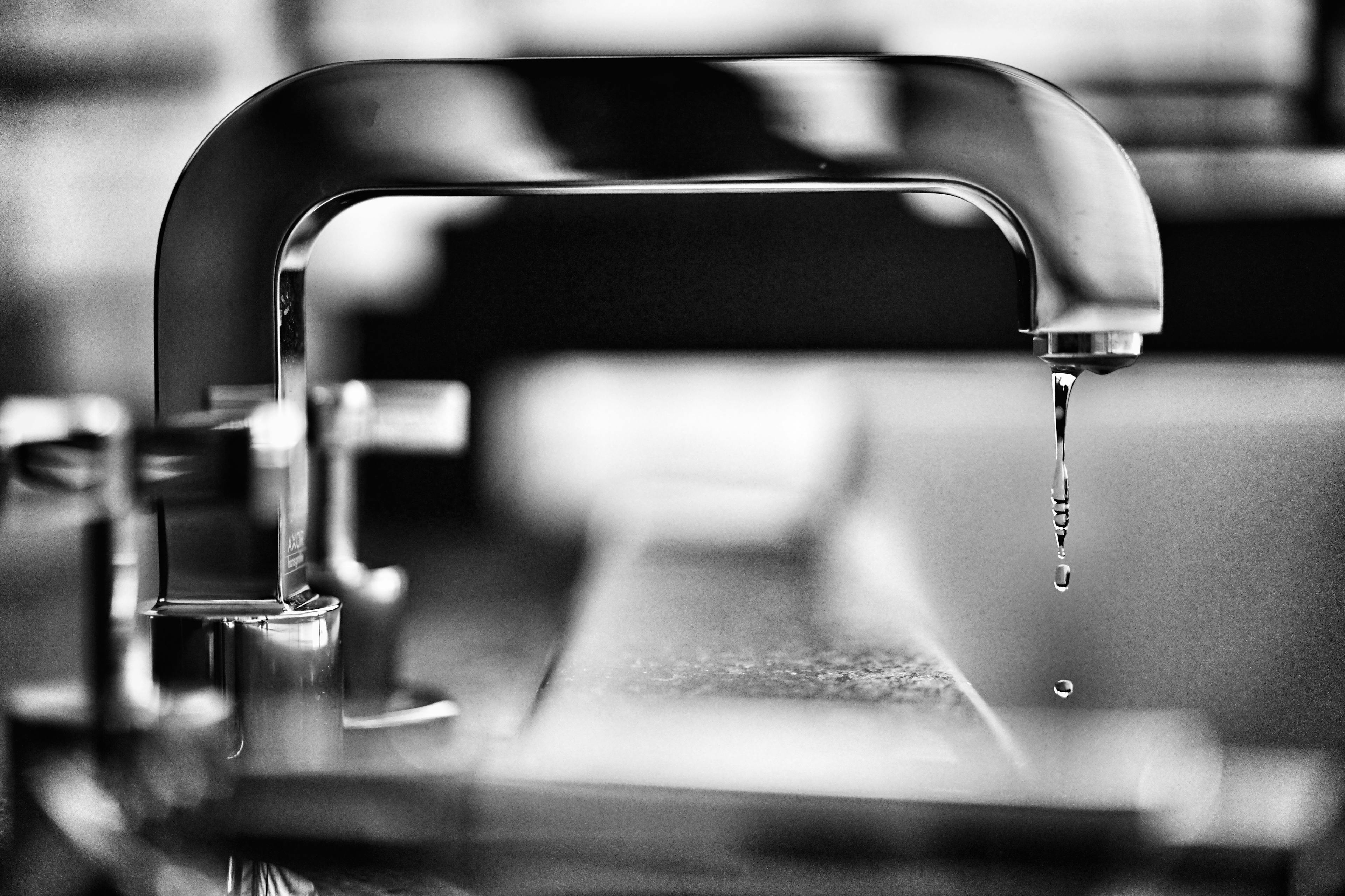 Black and white photo of dripping faucet